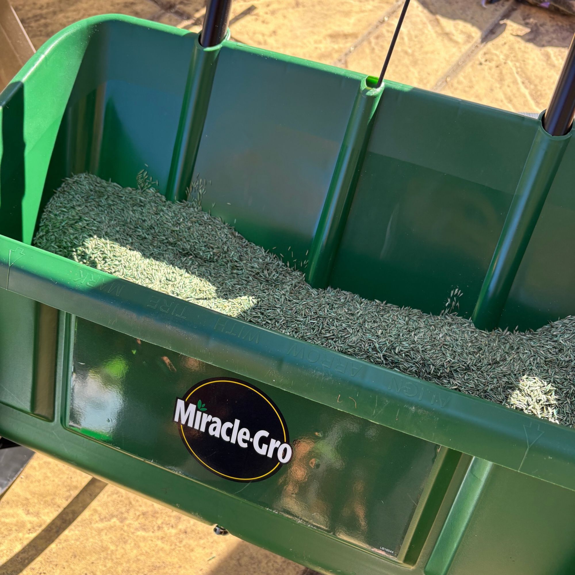 Miracle-Gro Drop Spreader hopper with lawn seed