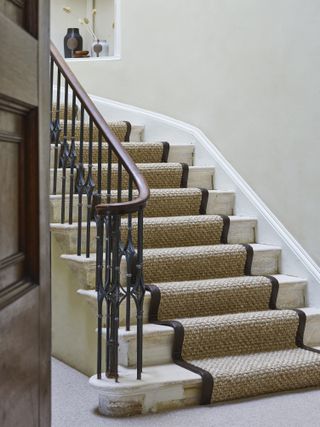 Stone staircase with runner in natural colourway and neutral coloured wall