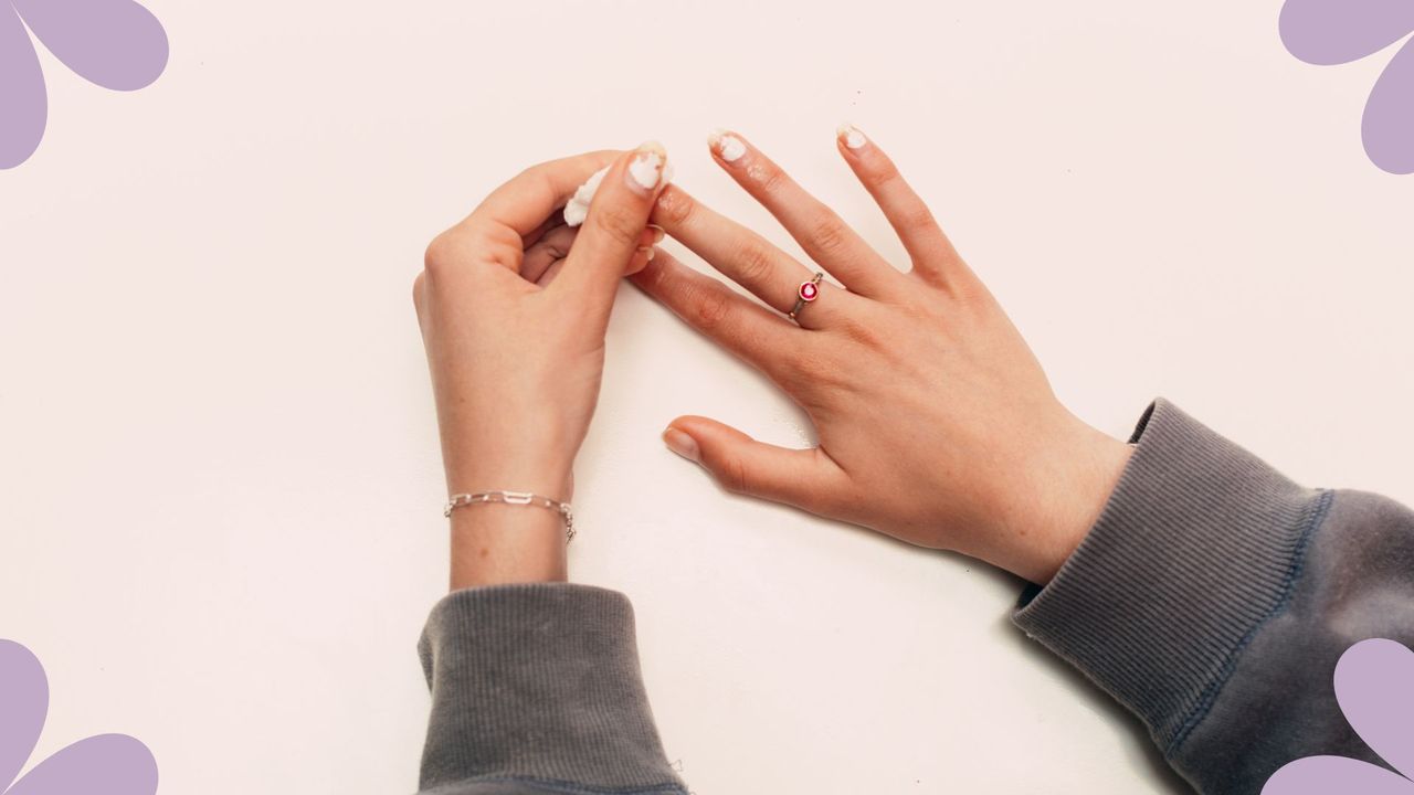 A woman&#039;s hands removing nail polish, to illustrate is acetone bad for your nails 