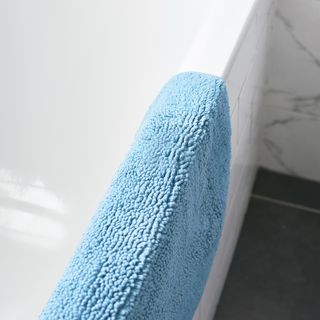bathroom with white tiles and blue towel