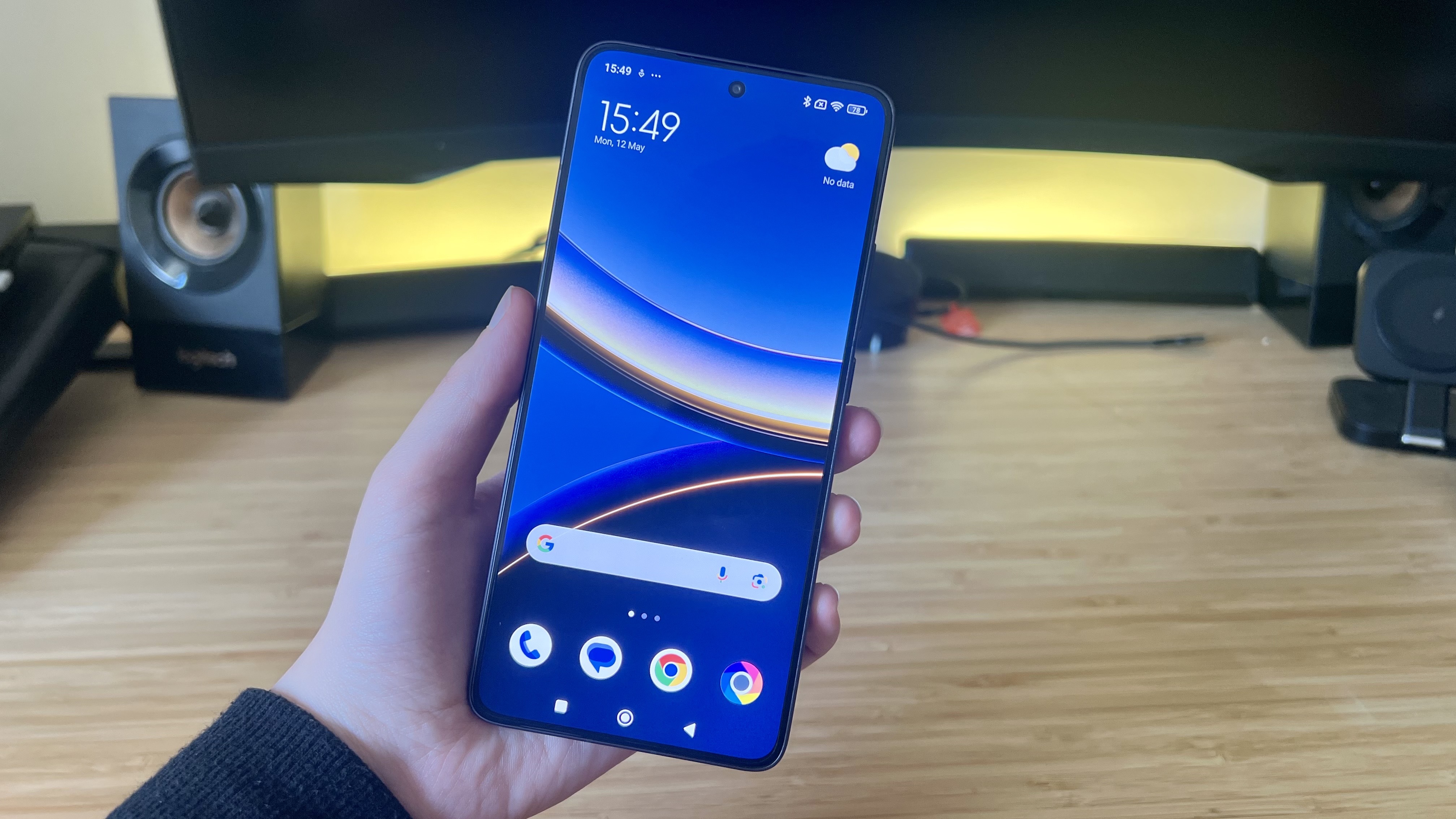 Hand holding Poco F7 Pro phone on home screen