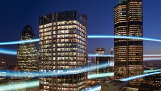 UK tech jobs: Beams of light flowing through high-rise buildings in Canary Wharf, denoting UK technology