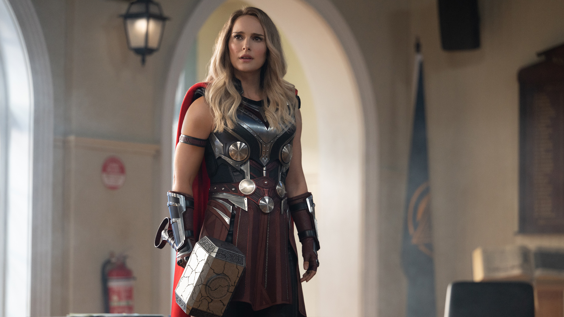 Jane Foster's Mighty Thor stands in the throne room of New Asgard while holding Mjolnir in Thor: Love and Thunder