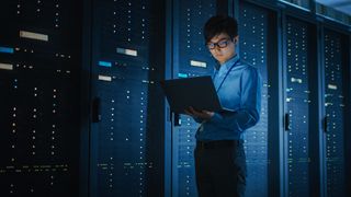 it engineer in server room with a laptop