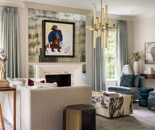 Living room with blue seating, a cream sofa and marble coffee table