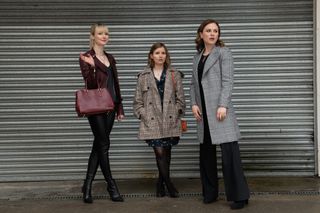 Lydia Wilson, Rebecca Benson and Anna Paquin stand in front of a storage unit