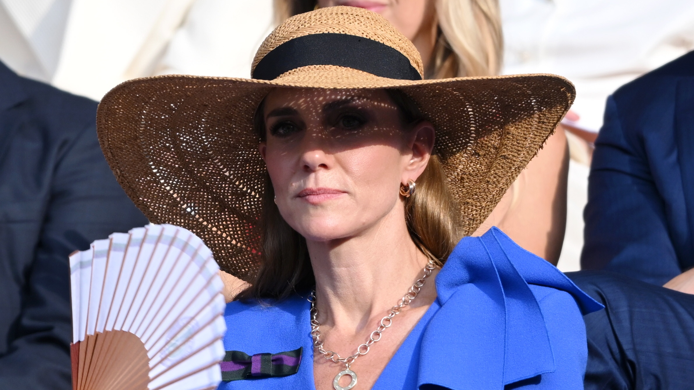Catherine, Princess of Wales holds a fan and wears a sunhat on day fourteen of Wimbledon 2025