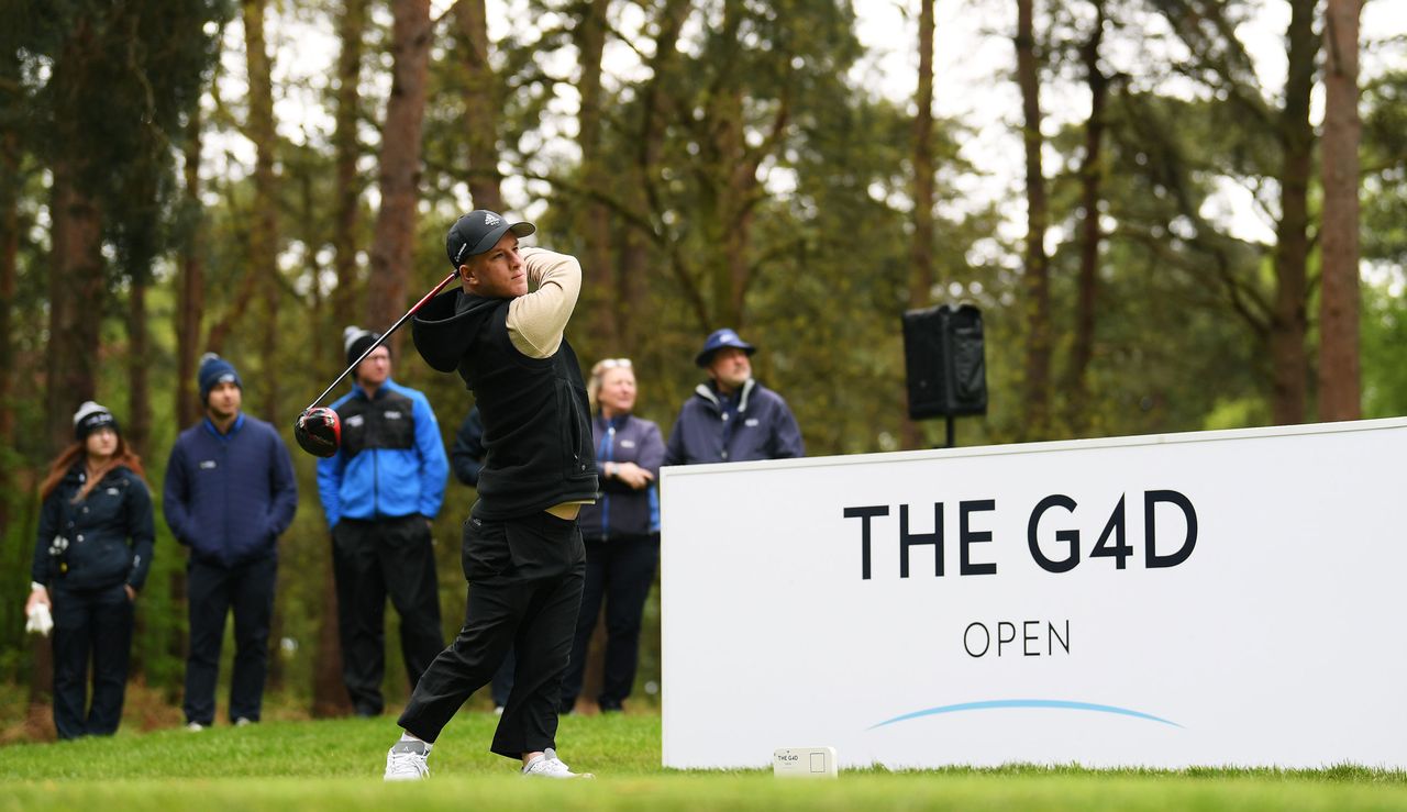 Lawlor strikes his tee shot in front of a G4D Open board