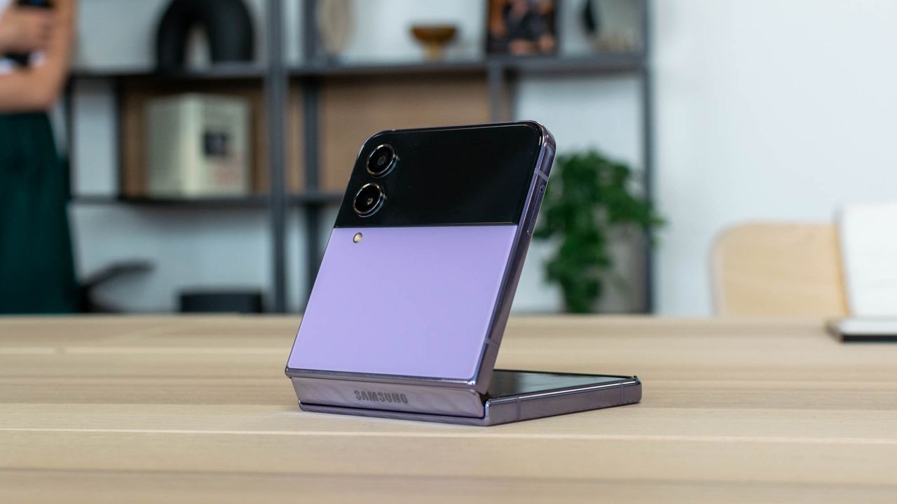 A photograph of the rear of the Samsung Galaxy Z Flip 4 half-open on the table