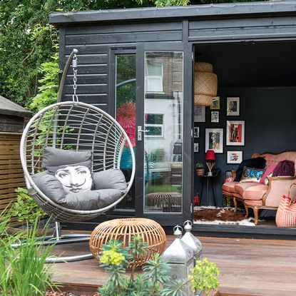 garden area with black shed and swing