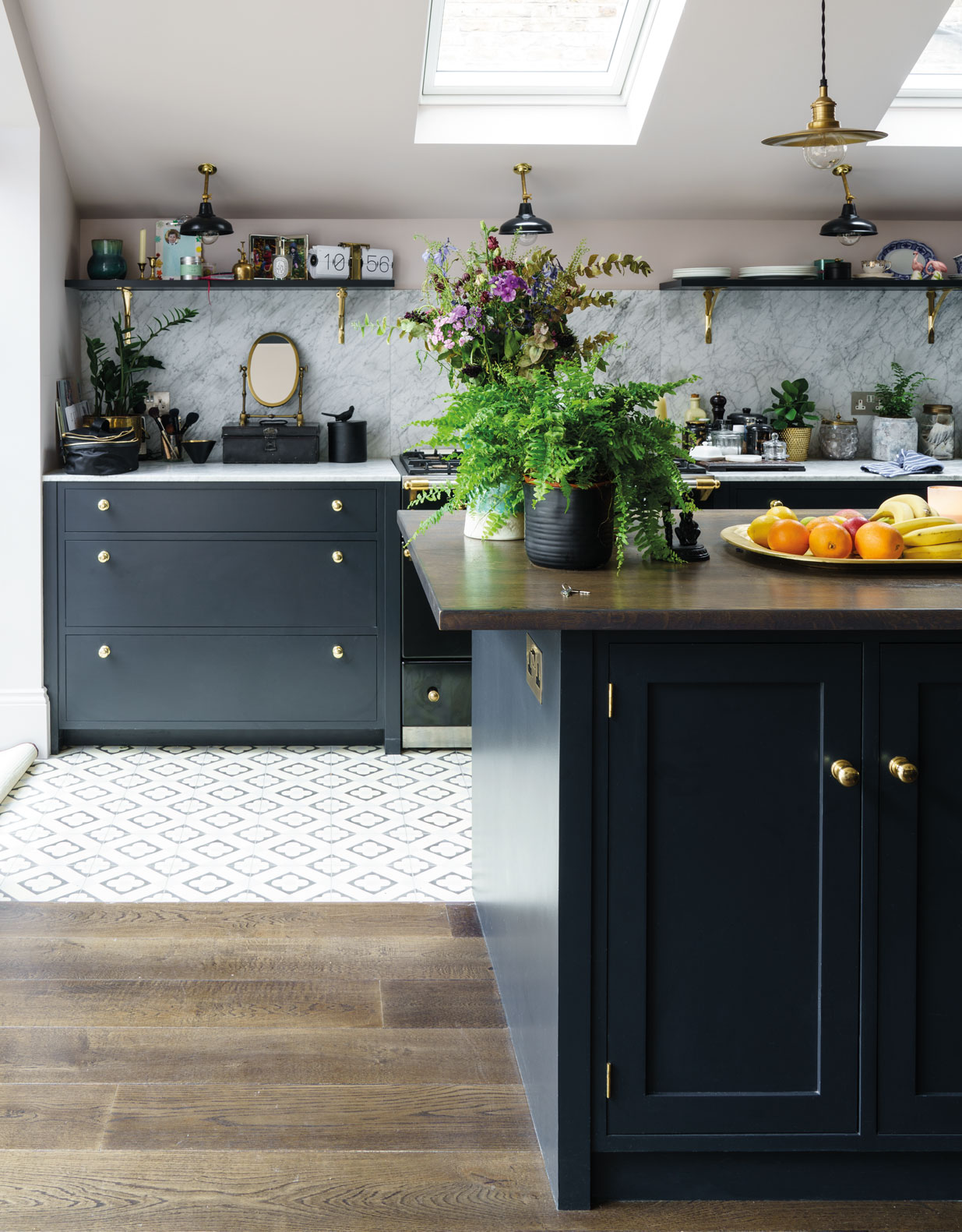 A combination of textures, with marble wall, wooden surfaces, and tiled floor complimented by simple black base cabinets and shelves