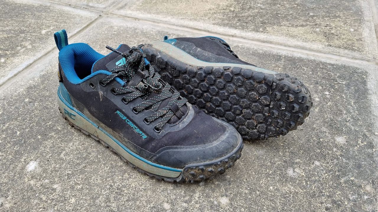 A pair of Ride Concepts Flume in blue, with one shoe laying on its side to expose the tread on the sole
