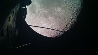 cylindrical spacecraft components in front of the cratered grey surface of the moon 