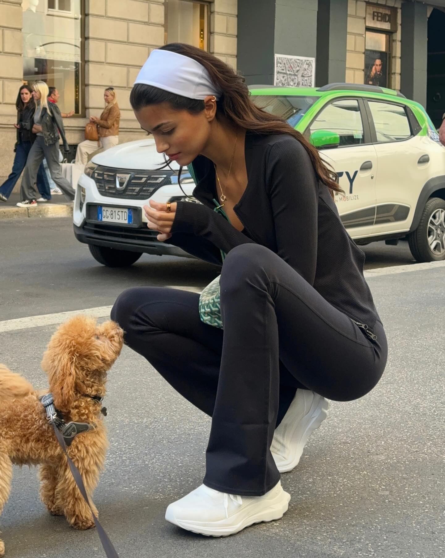 Kika wears a white headband, black long-sleeve shirt, black pants, and alo white runner sneakers.