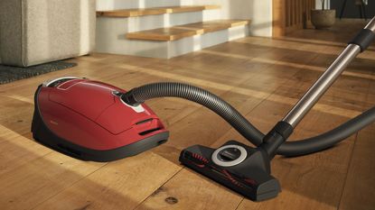 A hallways with a sideboard being vacuum cleaned