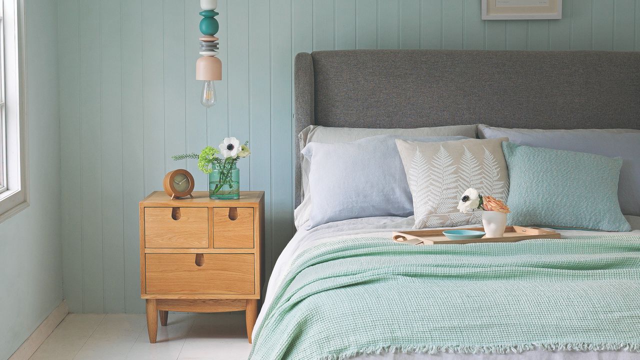 Bedroom with a bed, bedside table and low-hanging pendant light