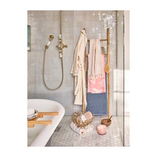 Rustic towel ladder with coral design towels hanging in a relaxed fashion.