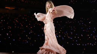 Taylor Swift twirling in a flowy dusty pink dress