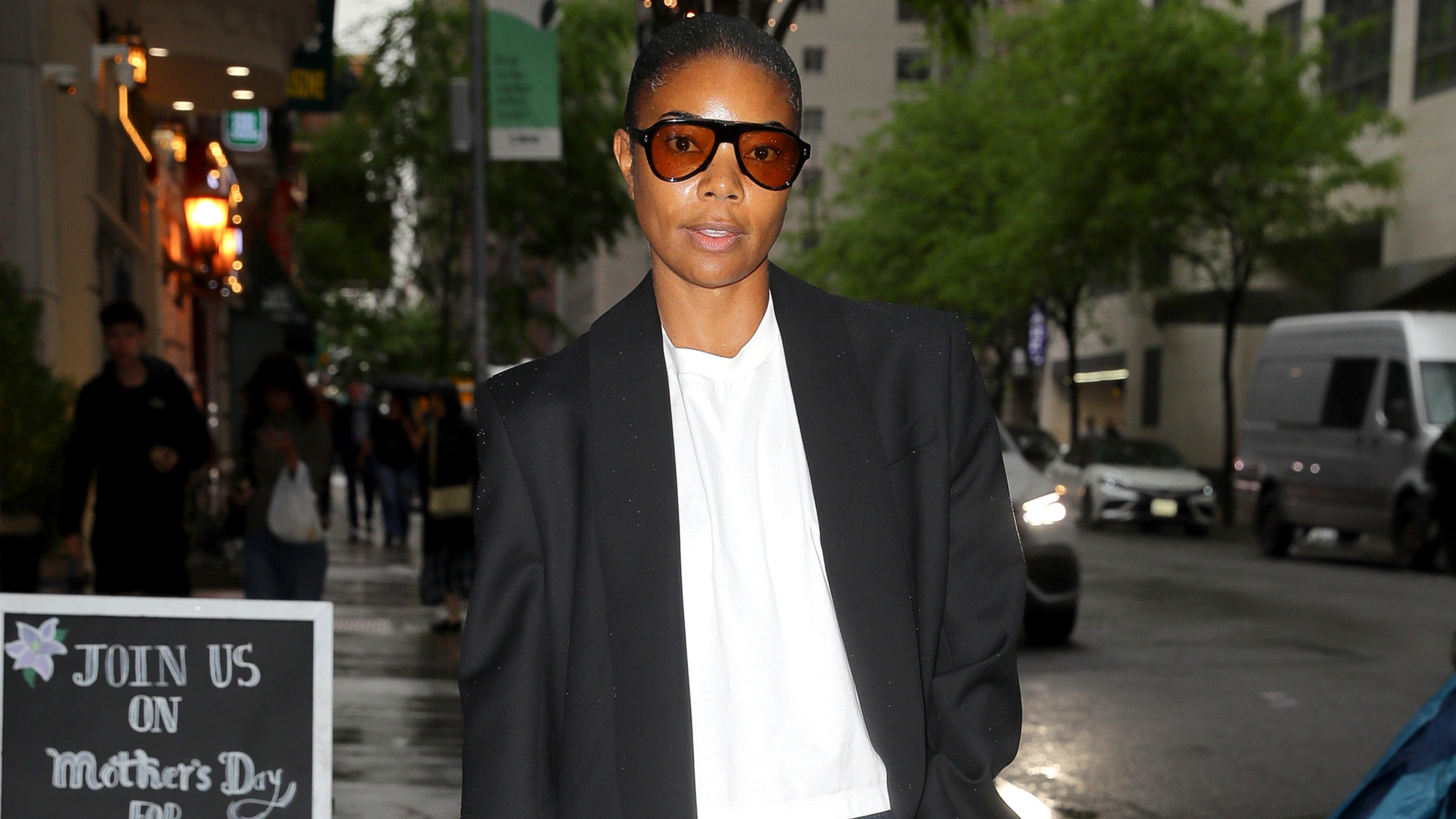 Gabrielle Union wearing a blazer coat, a white tee, and jeans 
