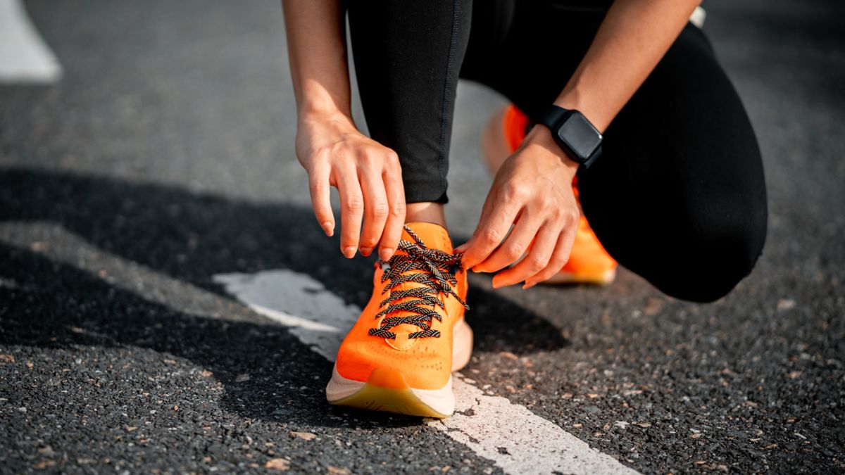 a photo of a woman tying her running shoes