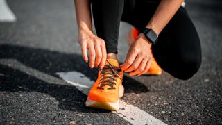 a photo of a woman tying her running shoes