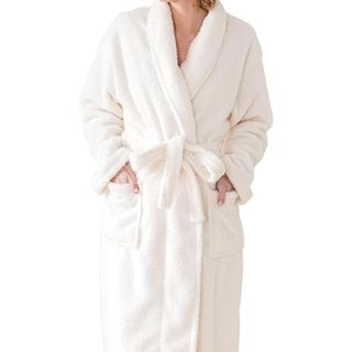 A fluffy white bathrobe being worn by a woman, tied with a bow in the front