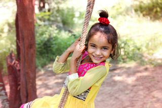 how to design a child friendly garden: girl on rope swing