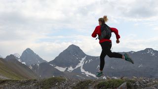 Runner in mountains wearing running backpack