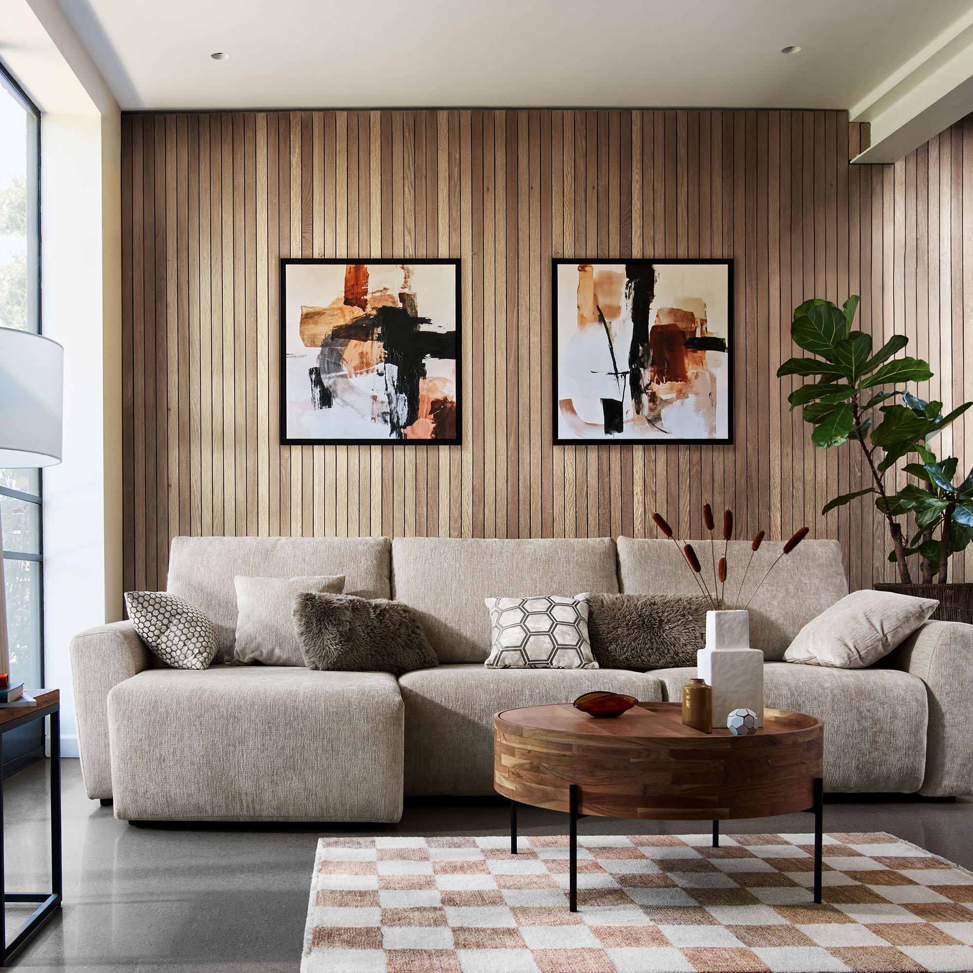 Cream contemporary corner sofa in a modern room with light wood panelled wall and a checkerboard rug