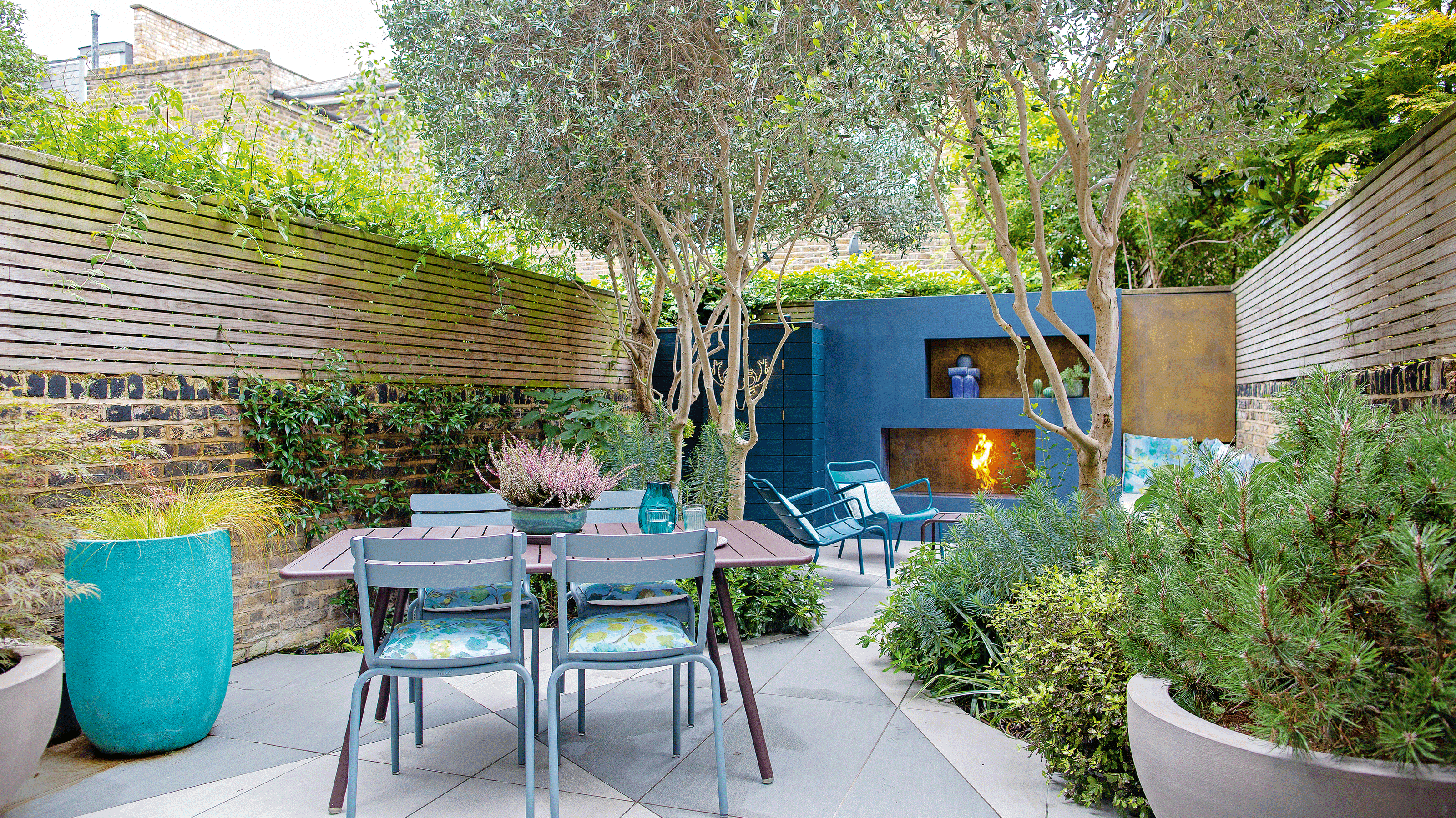 Dark grey table and chairs on patio with colourful cushions