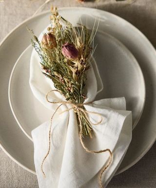 a Thanksgiving table setting topped with a mini dried flower bundle