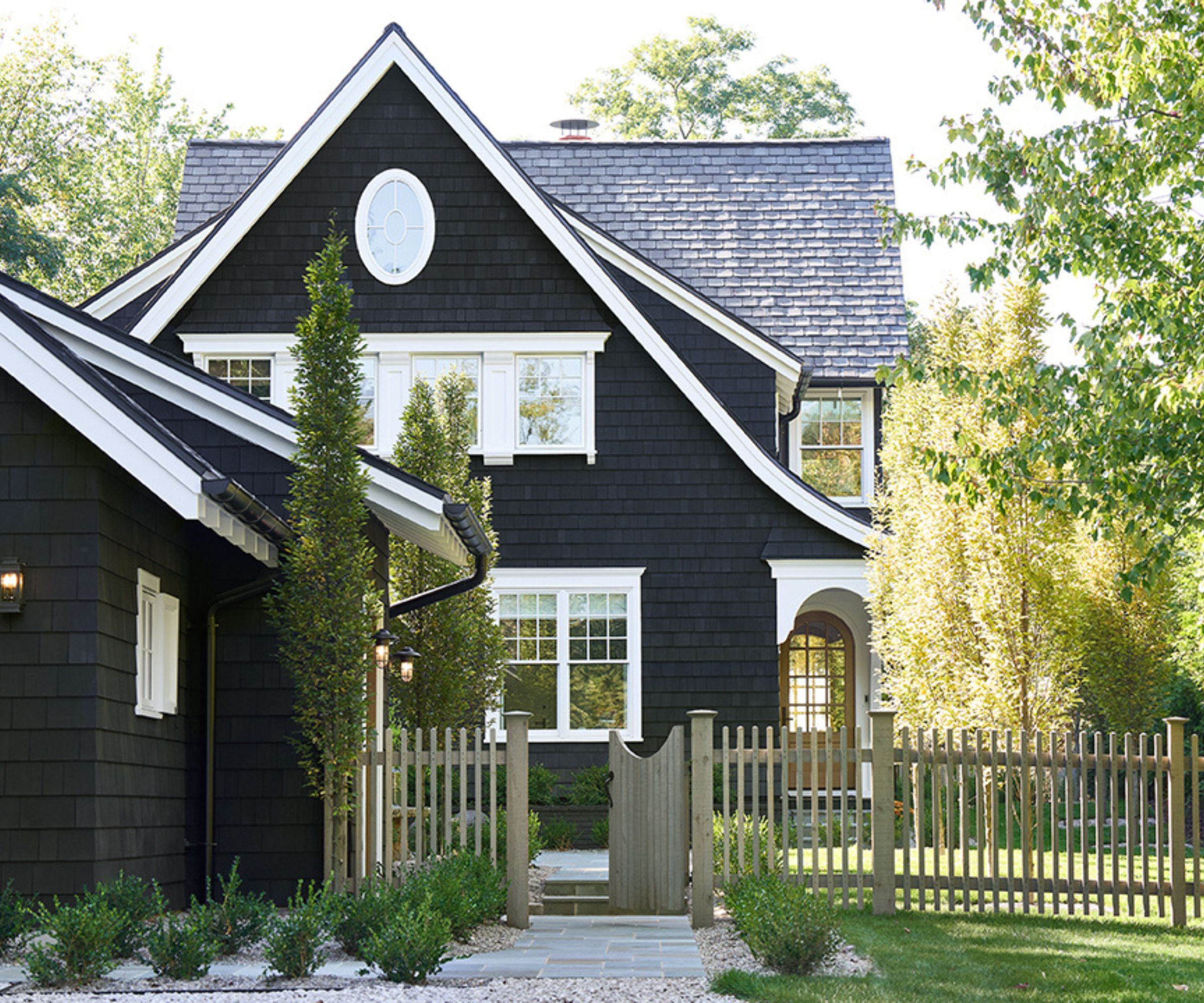 Exterior of a home with timber facade, white accents and black painted walls
