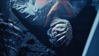 scene from a movie showing an alien creatured wrapped around a man's head.