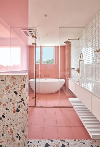 A pink-toned bathroom with pink and terrazzo tiles