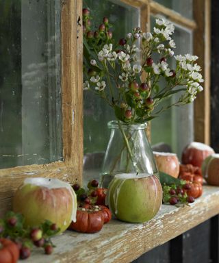 Fall craft idea with apples hollowed out for candle wax and flowers