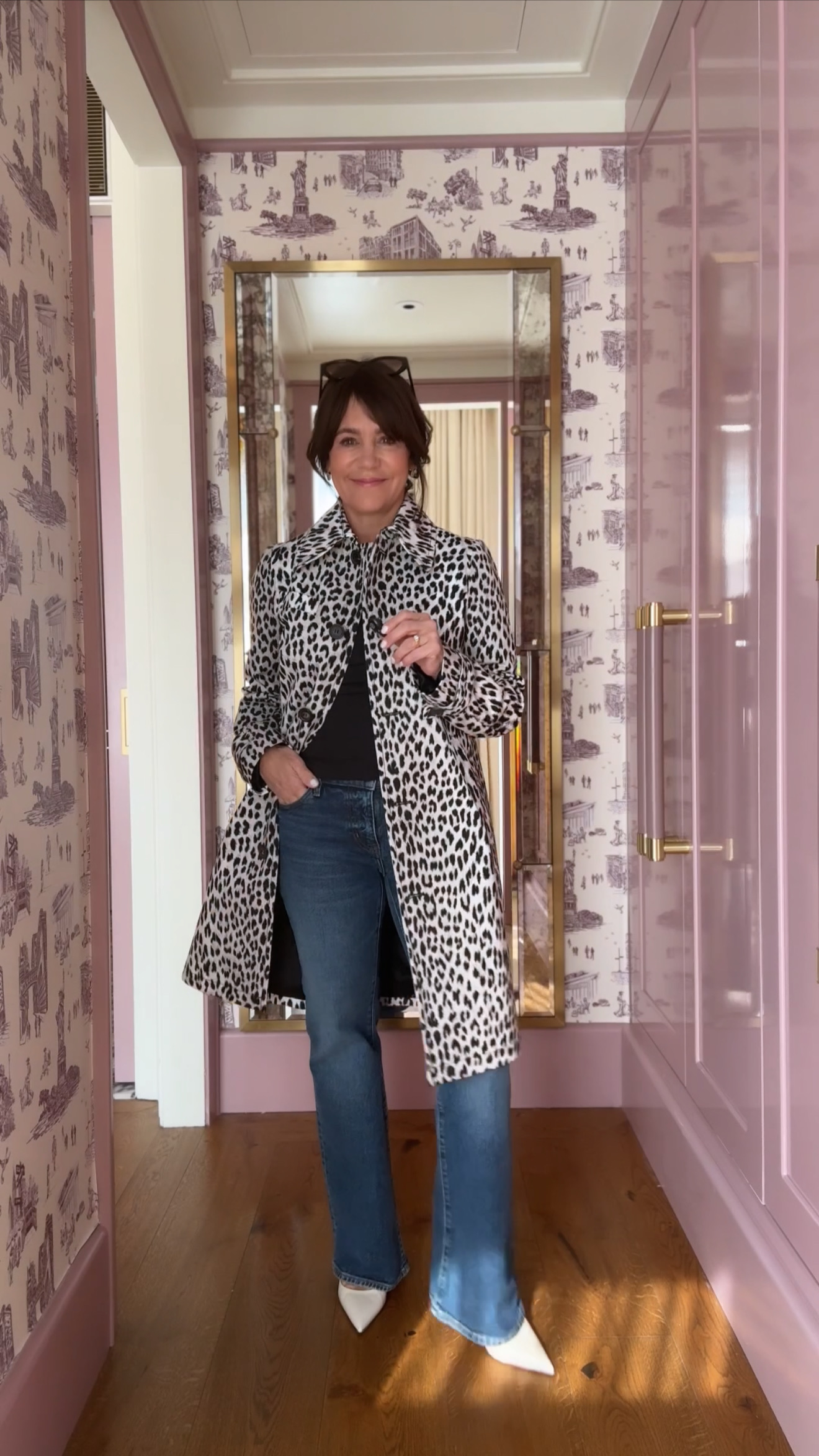 A former Nordstrom buyer wearing an animal-print trench coat and blue straight-leg jeans.