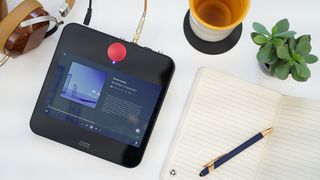 The Volumio Motivo audio device on a desktop next to a notebook