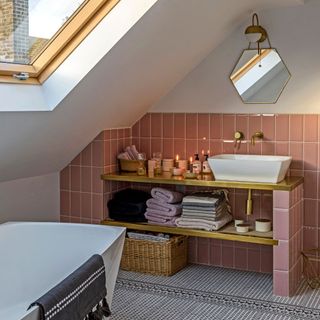 bathroom in a loft conversion with velux window, pink tiles, and a freestanding bathtub