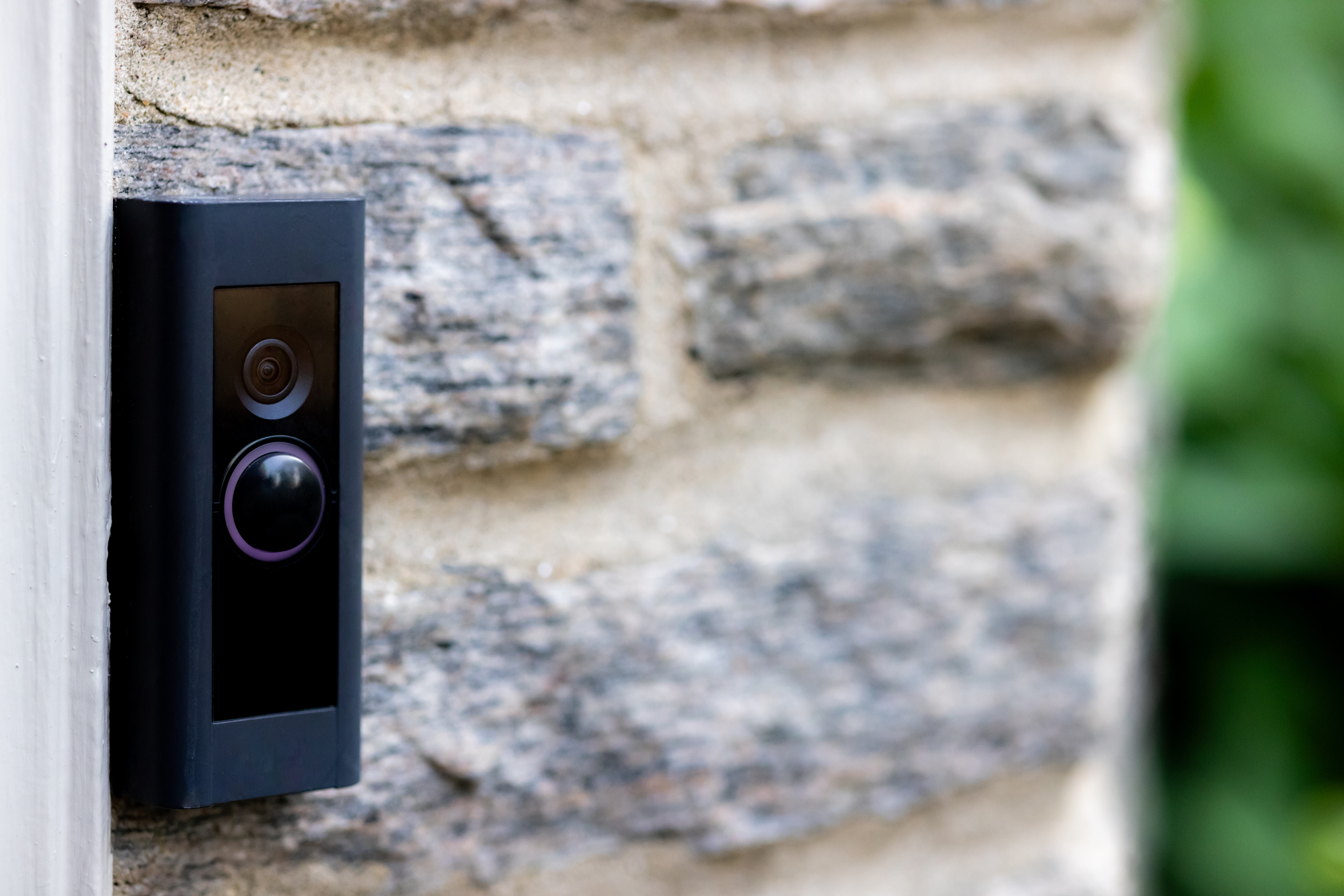 Video camera smart doorbell on residential stone wall background