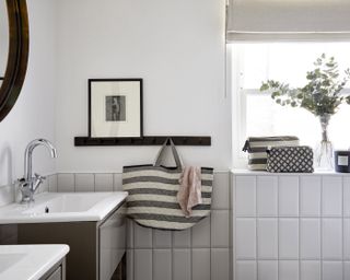 bathroom with black hooks and a bag hanging next to the basin