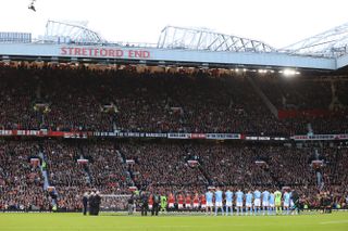 Manchester United and Manchester City players during a minute's applause for Sir Bobby Charlton at Old Trafford in October 2023.