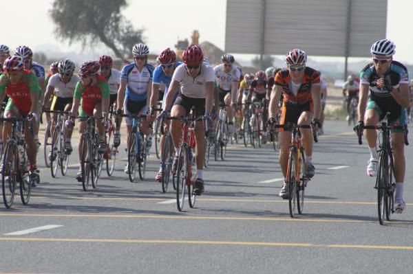 A KTM rider leads the peloton across the line