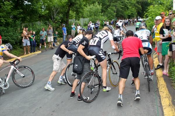 Women riders get stopped on the steep hill and need help getting going again.