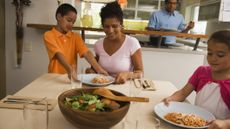 Family sitting around table with plates of pasta
