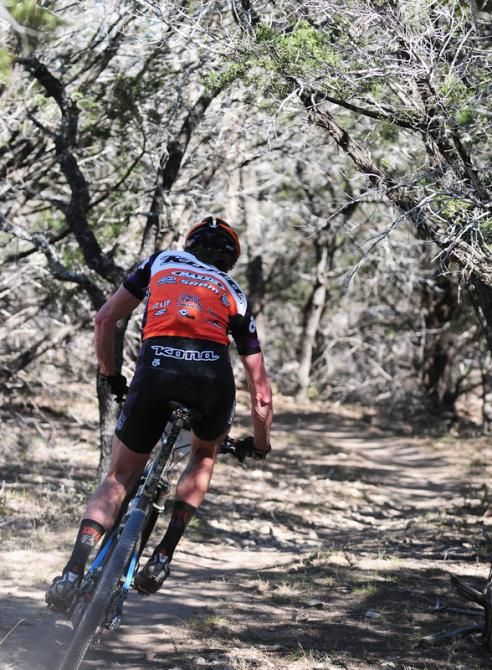 Barry Wicks (Kona) riding through thick forest on his final lap