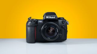 Nikon F100 sitting in front of a yellow background