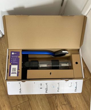 Dyson WashG1 wet floor cleaner packaged in cardboard box on wooden floor in Dan's home