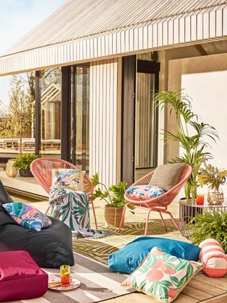 An external / outdoor scheme with garden furniture and assortment of colorful outdoor cushion decor