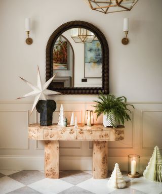 Console table in hall, star paper Christmas trees, mirror