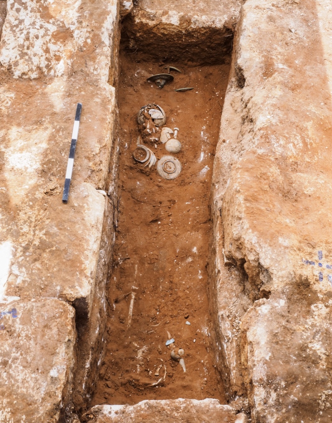 an excavated grave with scattered artifacts